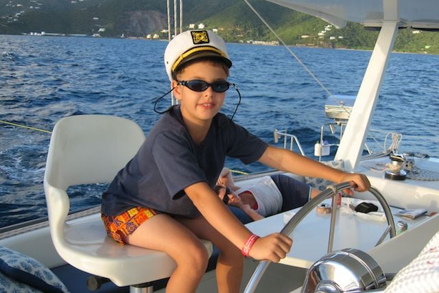 Child playing captain of the ship on a Virgin Islands Family Catamaran Charters