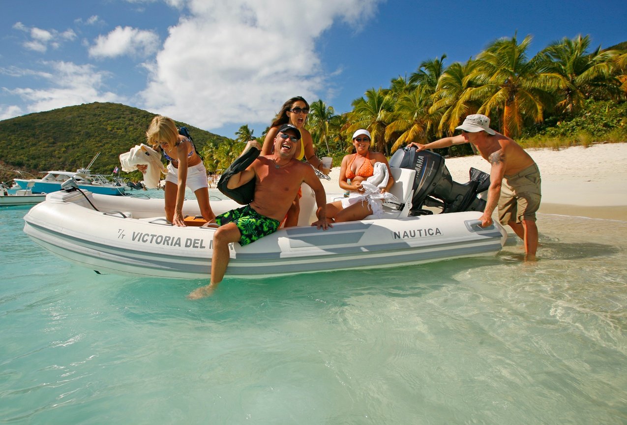 Picture of a group enjoying themselves on one of the water toys of a private luxury catamaran yacht charter.