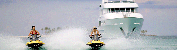 Two People Jet-skiing in the Bahamas in front of a Power Yacht Charter
